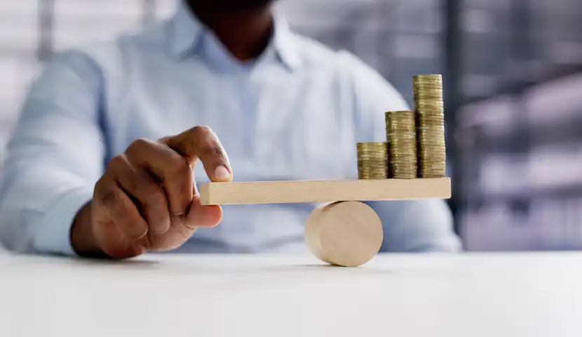 En mann som balanserer mynter på en vektstang